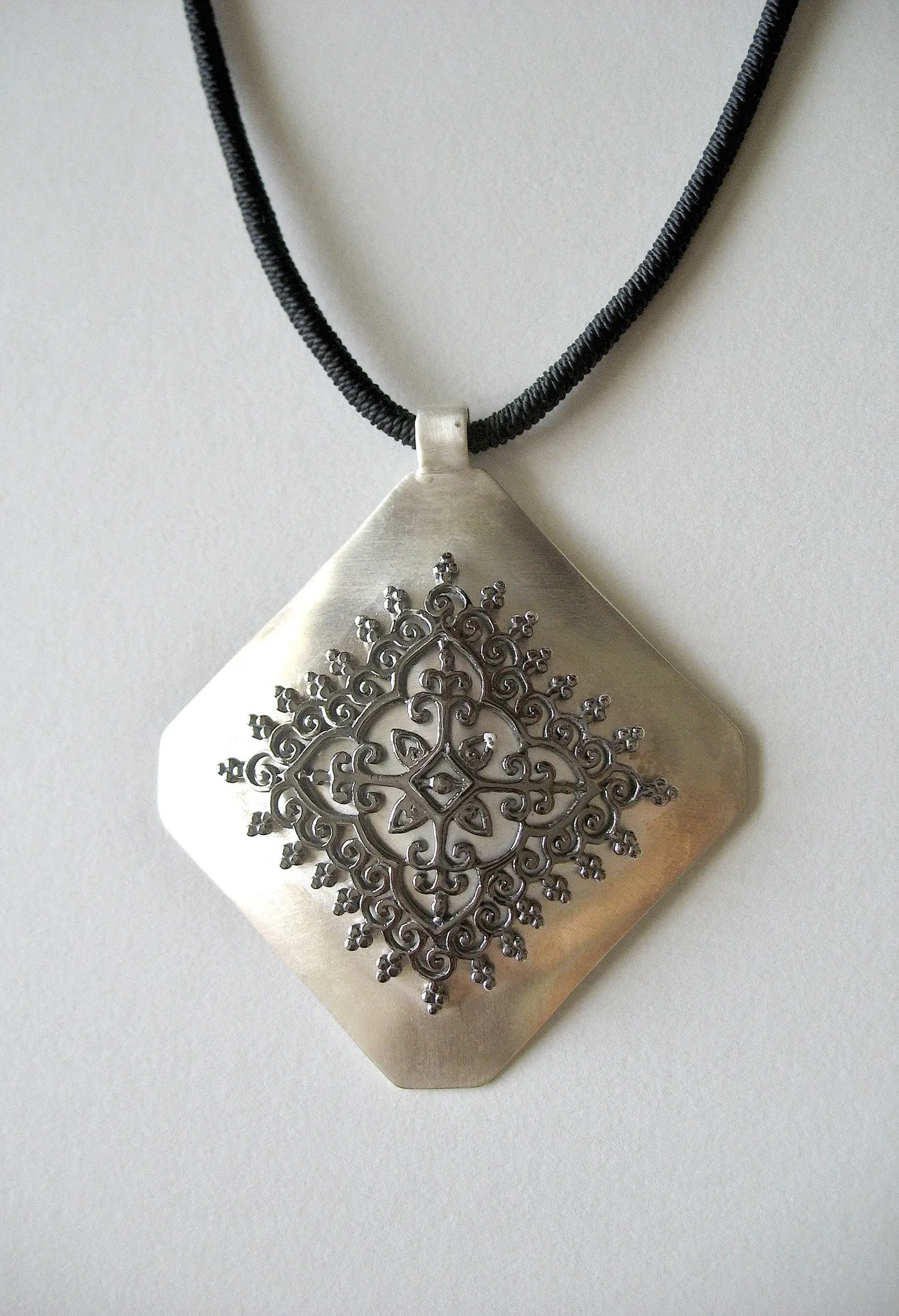 Gorgeous, kite-shaped pendant with mehndi-inspired black rhodium plated center unit